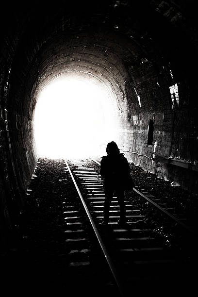istock Woman Silhouette Standing at Bright Light 621914498