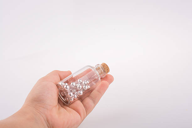 Little perfume glass bottle in hand on a white background