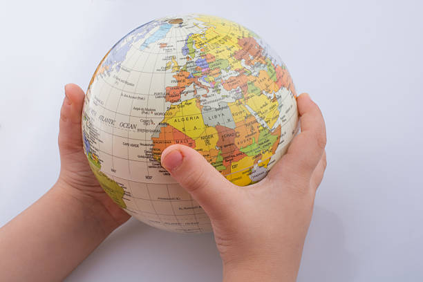 Child holding a globe in his hand on a white background