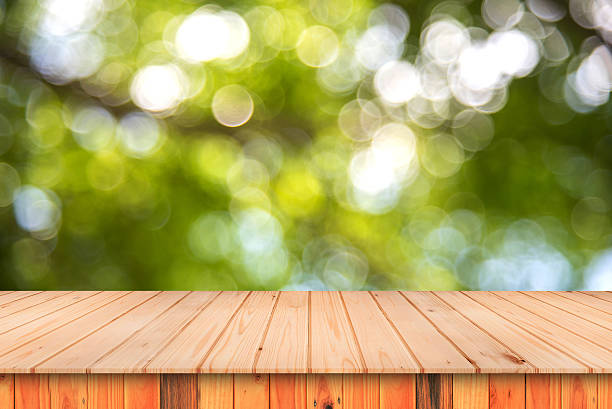 istock empty wooden table and abstract green spring bokeh. 621919714