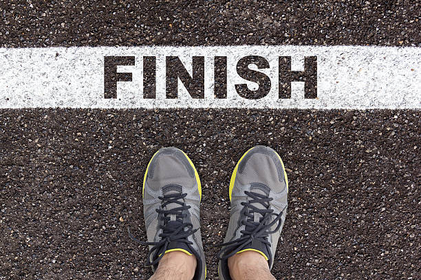 istock sport shoes on asphalt road texture with finish 621922694