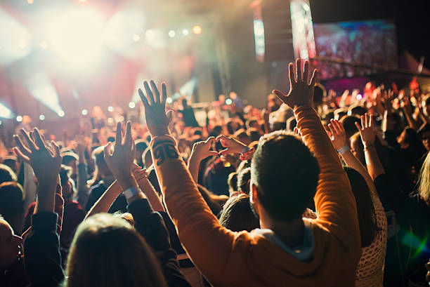 istock People raising their hands at a concert 621928524
