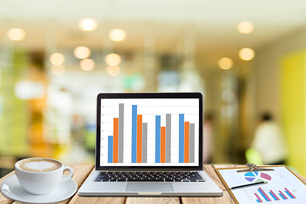 istock laptop with chart on wood table in office blur background 621928526