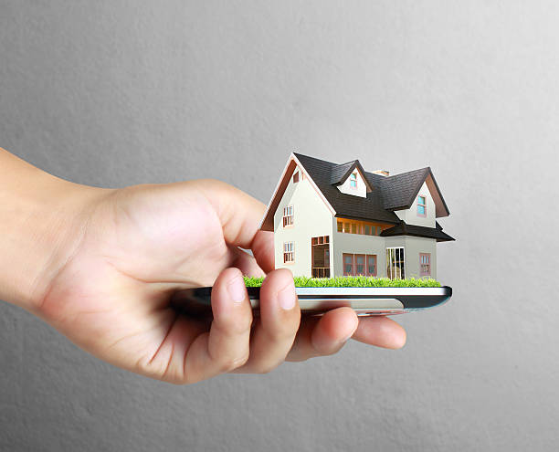 istock house on a mobile phone, in hand 621929818