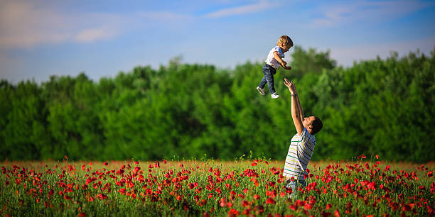 아버지는 양귀비 필드에 아들을 던져 - poppy field flower meadow 뉴스 사진 이미지