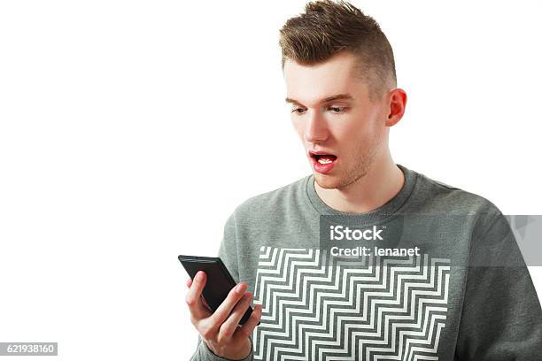 Amazed Young Man Using Smartphone Stock Photo - Download Image Now - 20-29 Years, Adult, Adults Only