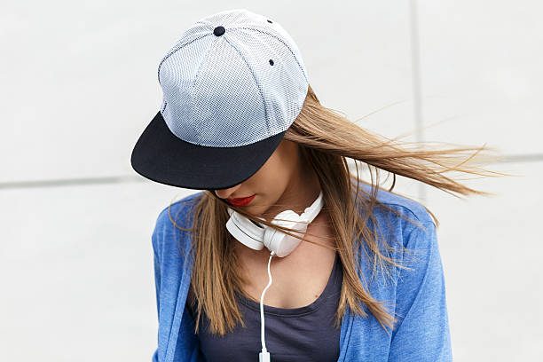 mujer joven con gorra y auriculares - city of nice audio fotografías e imágenes de stock