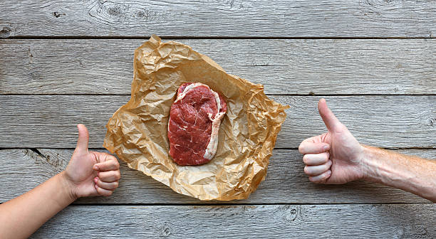 istock Raw beef steak on dark wooden table background, top view 621939718