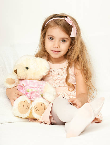istock child girl sit in bed with teddy bear 621971202