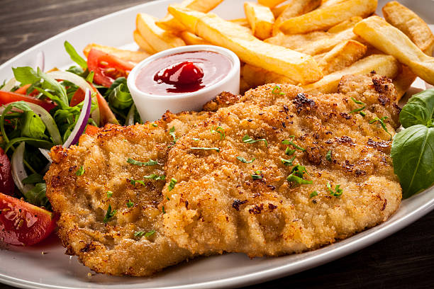Fried steaks, French fries and vegetables