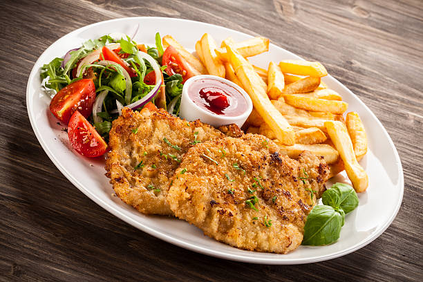 istock Fried steaks, French fries and vegetables 621971698