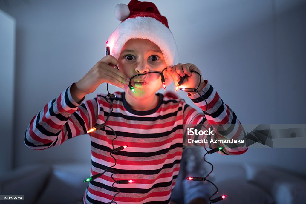 I am the Grinch! Young boy playing with the Christmas lights 10-11 Years Stock Photo