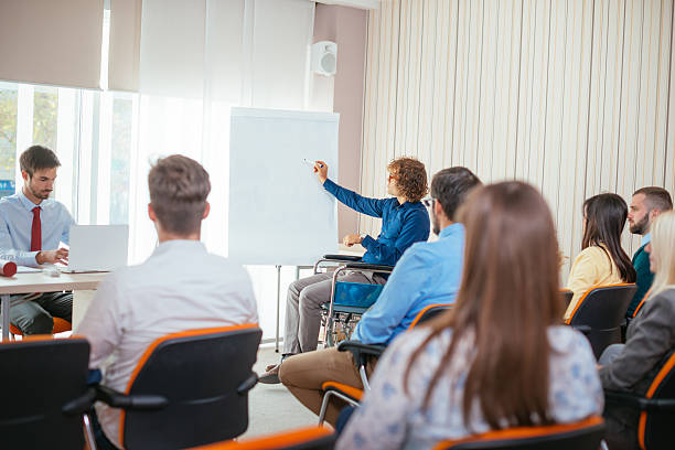 istock Paraplegic student and professor assistant in lecture hall 621973460