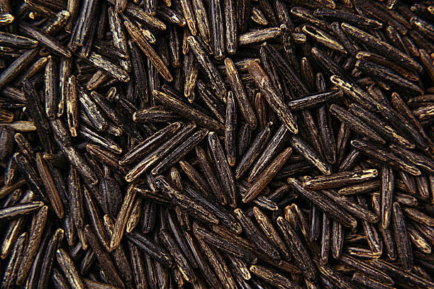 Black rice close-up background. Black rice close-up background. Heap wild brown unpolished rice for vegetarians. genmai stock pictures, royalty-free photos & images