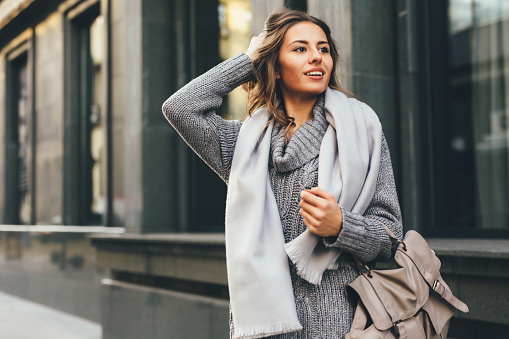 Happy winter time in big city charming girl standing street dressed funny fluffy hat. Enjoying snowfall, expressing positivity, smiling to camera, joyful cheerful mood, true emotions, Christmas mood