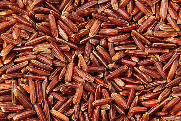 Red rice close-up background. Red rice close-up background. Heap wild brown unpolished rice for vegetarians. genmai stock pictures, royalty-free photos & images