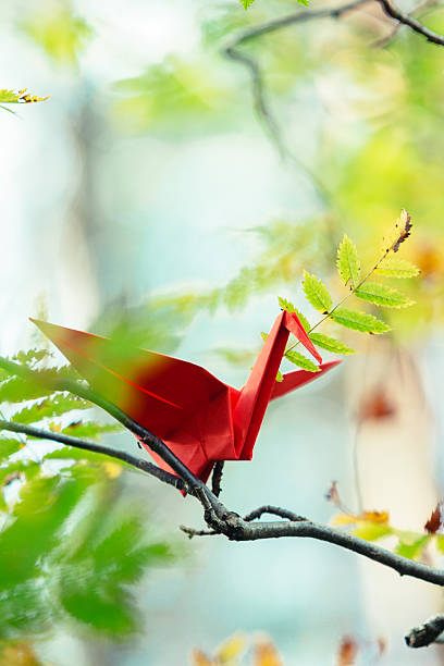istock Red origami crane on a tree branch 621977048