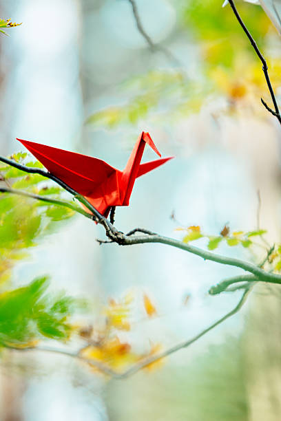 istock Red origami crane on a tree branch 621978222