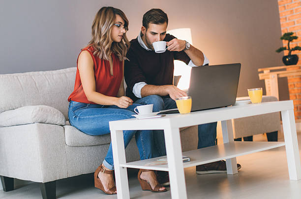 istock Cheerful couple at home using laptop 621981124