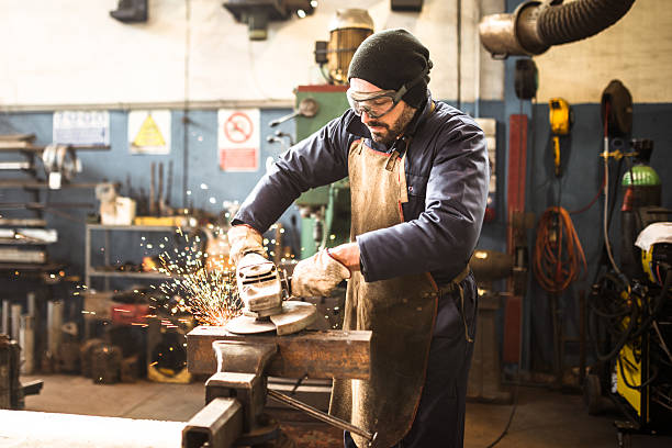 manual worker on a workshop with the grinder - grinding imagens e fotografias de stock