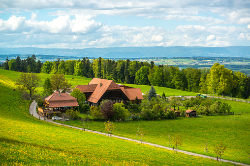 Bern, Switzerland - May 7, 2014: Rural landscape in Switzerland with road and complex of privately owned buildings