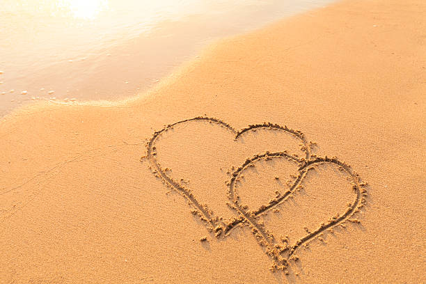 dwa serca narysowane w piasku, symbol miłości, miesiąc miodowy - beach love heart shape two objects zdjęcia i obrazy z banku zdjęć