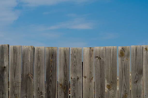 istock old wooden fence with gate on sky background 621986350