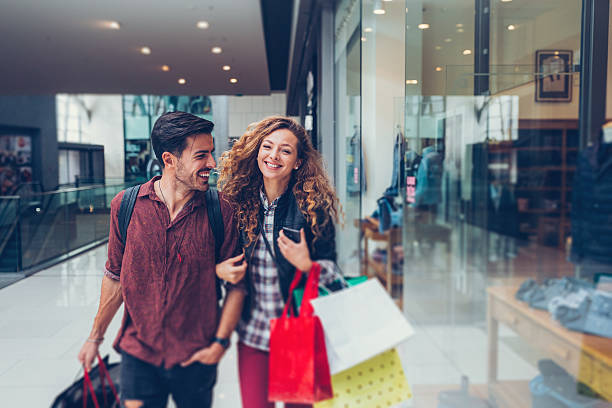 Young couple shopping in the mall Happy couple in the shopping center retail stock pictures, royalty-free photos & images