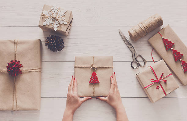 istock Woman's hands wrapping christmas holiday present with craft twine 621989028