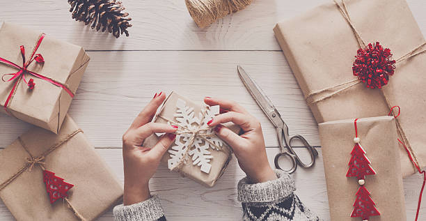 istock Woman's hands wrapping christmas holiday present with craft twine 621989496