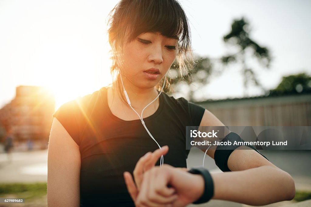 Woman monitoring her progress on smartwatch Close up shot of young sportswoman looking at smartwatch. Fitness female monitoring her progress on smartwatch. Healthy Lifestyle Stock Photo