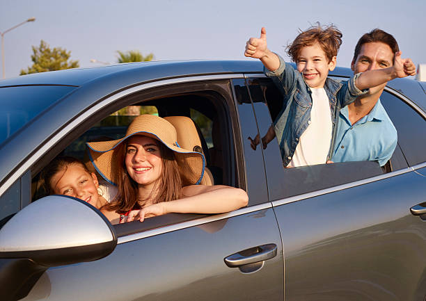 istock Happy family leaning out car windows 621989892