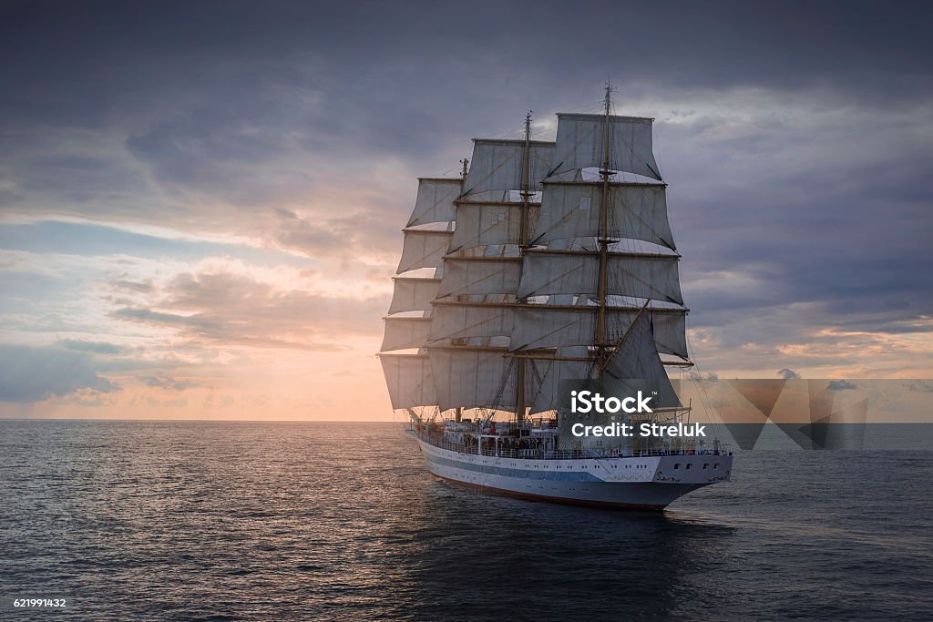 Ancient sailing ship in the sea Ancient sailing ship in the sea at sunset Tall Ship Stock Photo