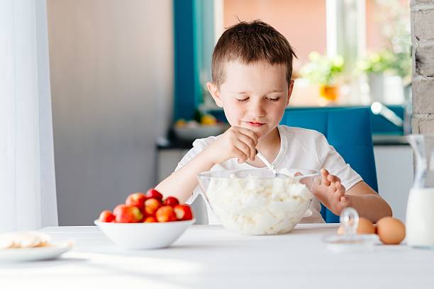 istock Boy mixing white cheese in bowl for cheesecake. 621993542