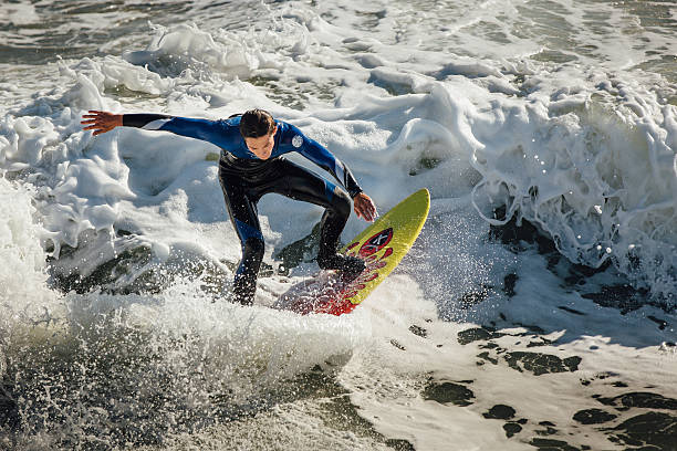 Young male surfer riding a frothy wave stock photo