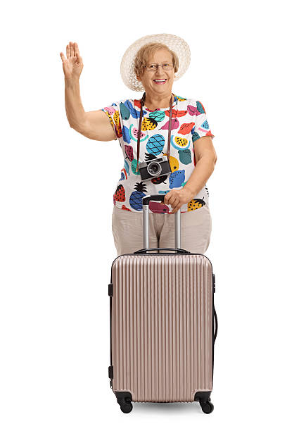 istock Cheerful mature tourist with a suitcase waving 621994478