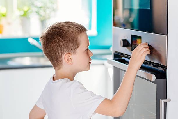 istock Child regulating temperature of the oven . 621995116