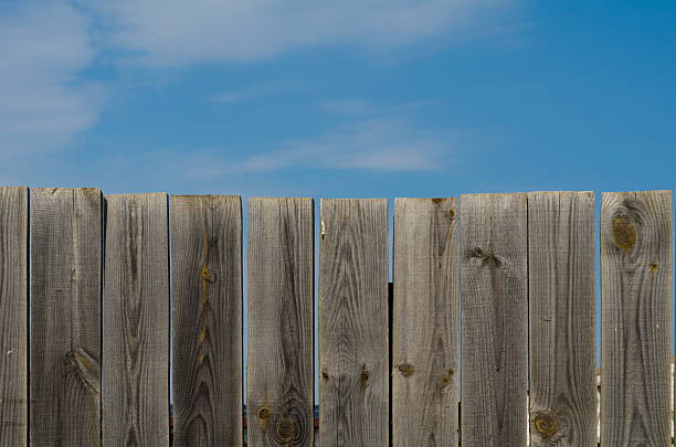 Old and weathered wood fence with blue sky and plenty of copy space. See also ...