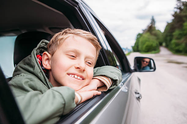 istock Dreaming boy look out from the car window 621996248