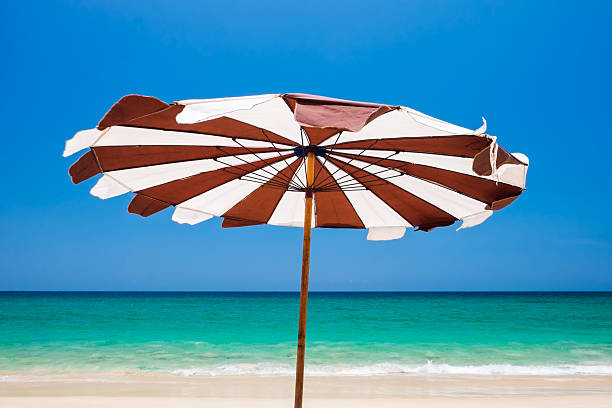 istock Umbrella on a tropical beach vacation. Phuket island, Thailand. 621996368