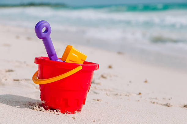 istock kids toys on white sand beach 621998372