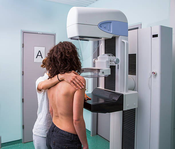 Nurse with young women having a mammography Nurse with young women having a mammography x ray image medical occupation technician nurse stock pictures, royalty-free photos & images