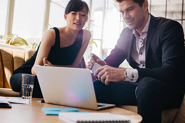 istock Businesspeople sitting in lobby and working on laptop 622003546