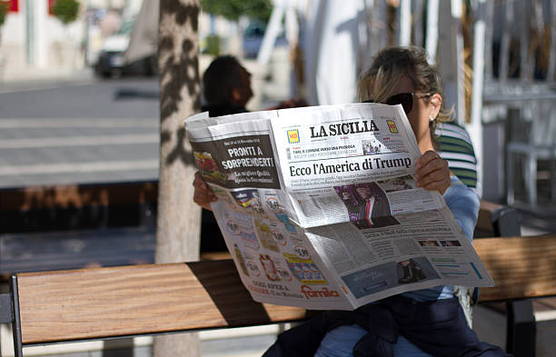 italy: woman reads newspaper with headline: here's trump's america - donald trump presidente dos estados unidos imagens e fotografias de stock