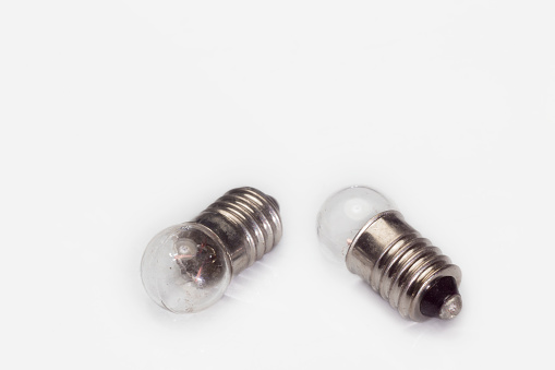 Two small light bulbs on a white bacjground