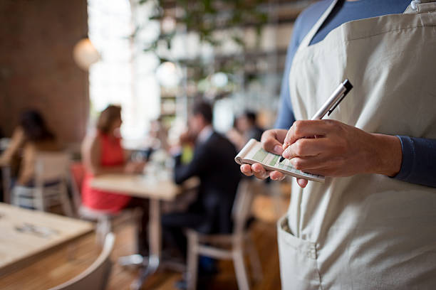 Woman working at a restaurant Close-up on a woman working at a restaurant as a waitress and holding a notepad waitress stock pictures, royalty-free photos & images