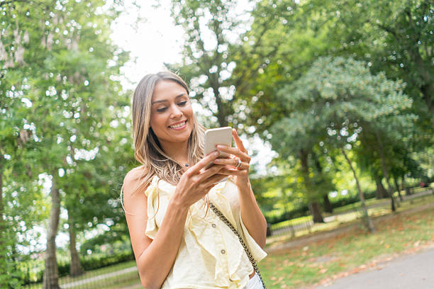 istock Woman texting on her phone at the park 622009810