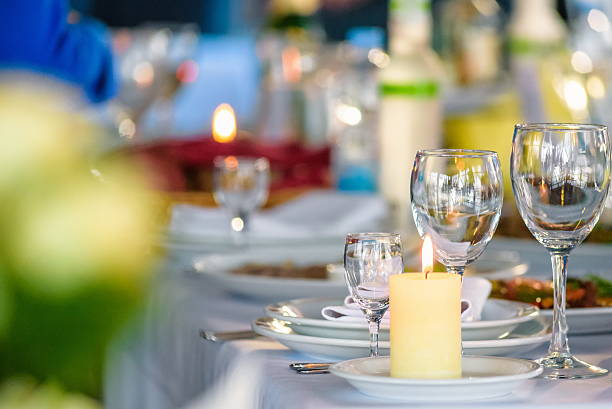 istock Glasses, forks, knives, napkins and decorative flower on a table 622010374