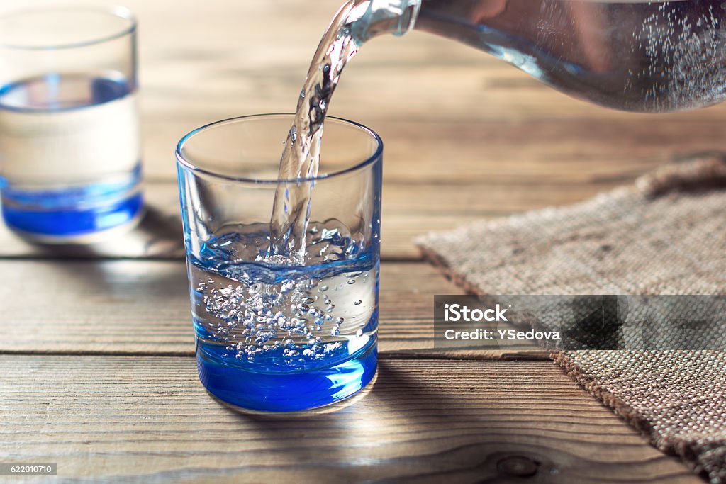 Water was poured into the beaker Glasses of water on a wooden table. Water was poured into the beaker. Selective focus. Shallow DOF Drinking Glass Stock Photo