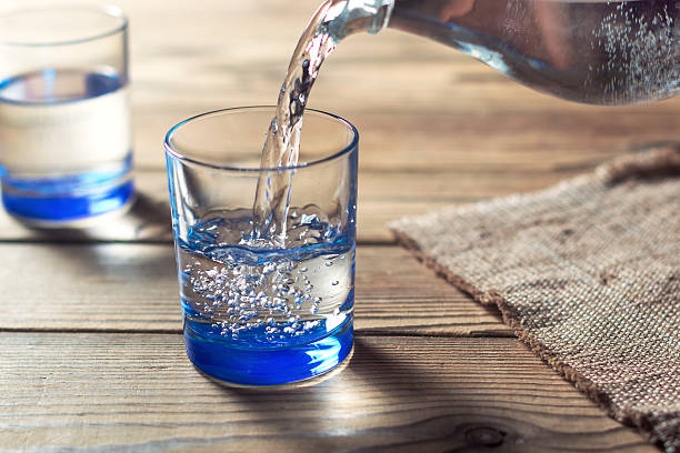 Water was poured into the beaker Glasses of water on a wooden table. Water was poured into the beaker. Selective focus. Shallow DOF purified water photos stock pictures, royalty-free photos & images